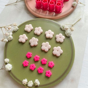 Flower-shaped polymer clay cutters with five-petal cutouts in pink and white