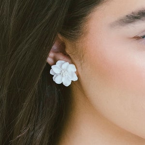 White floral stud earrings with 5-petal clay flower on ear