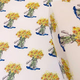 Daffodil wrapping paper with repeating yellow flower bouquets and blue accent bows
