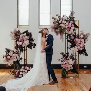 Metal wedding flower stand with geometric floral arrangement in pink and white blooms