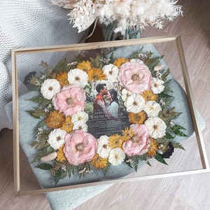 Framed preserved wedding flowers: pink roses, white daisies, yellow blooms in glass shadowbox