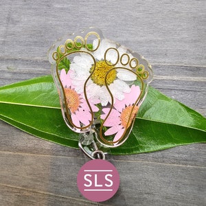 Floral badge reel with crown-like frame and pink rose illustration on badge holder