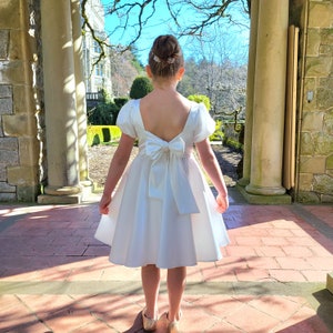 White satin flower girl dress with puff sleeves and back bow