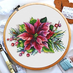 Poinsettia flower cross stitch pattern in embroidery hoop with berries and green leaves