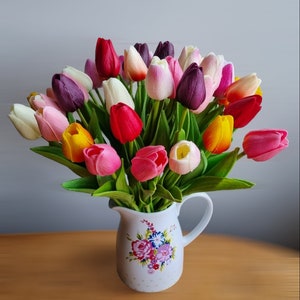 Artificial tulip bouquet in ceramic vase with red, pink, purple, white, and yellow blooms