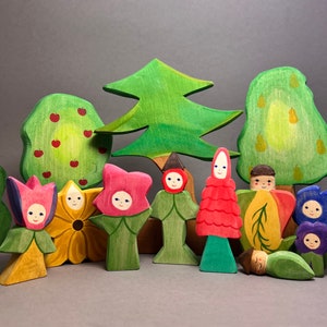 Set of colorful wooden flower children figures with green tree decoration
