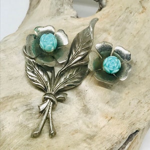 Vintage floral brooch with turquoise flower center and leafy gold-tone pin