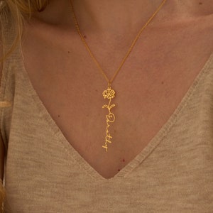 Gold name necklace with delicate birth-flower charm and vertical script pendant