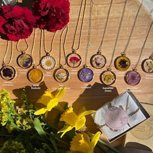 Hand-pressed flower necklace set with round pendant charms and layered metal chains
