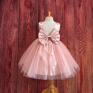 Blush pink tulle flower girl dress with ruched bodice and large satin bow