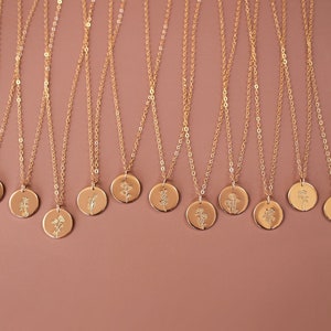 Gold birth flower necklace with round pendant on a fine chain