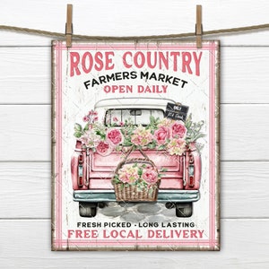 Pink rose-themed farmers market hanging sign with truck and floral display