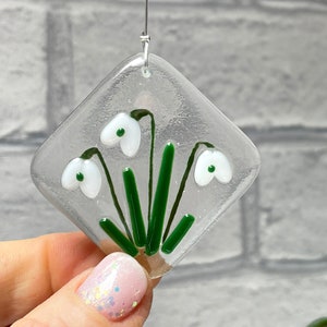 Fused glass snowdrop window hanging: clear diamond with green stems and white flower blooms