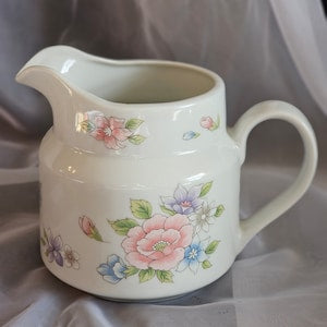 Vintage porcelain creamer pitcher with pastel floral painted design and handle