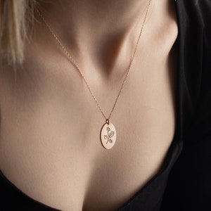 Gold oval birth-flower pendant necklace on thin chain