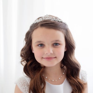 Rhinestone flower girl tiara on a girl's head, silver sparkle crown.