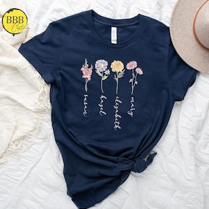 Navy floral birth-month T-shirt with pastel flower and script lettering