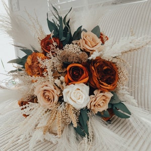 Burnt orange and ivory wedding bouquet with sage green leaves, roses, and dried grasses