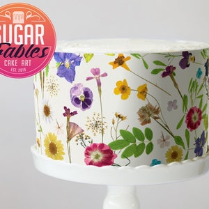Edible floral cake wrap with pressed dried flowers and butterflies printed around cake
