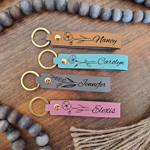 Gold-tone keychains with floral bar charms and engraved name tags in turquoise and pink