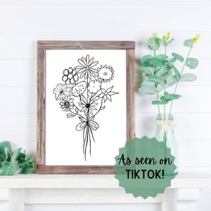Framed floral line art bouquet with black ink flower stems in a wooden frame