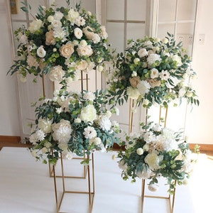White and green floral ball arrangements on standing frames with leafy accents