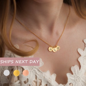 Gold-tone mom necklace with small circular birth-flower style charms on a fine chain