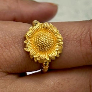 Gold sunflower detail statement ring with textured petals on a slim band