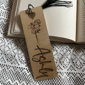 Tan paper bookmark with line-art flower and cursive name text