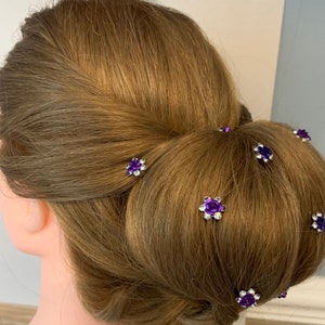Purple flower hairpins with silver-tone metal on a bun hairstyle