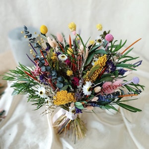 Multicolored dried flower bouquet with greenery, daisy-like white blooms, and yellow accents