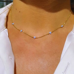 Gold-tone necklace with tiny blue flower pendant charms and short chain