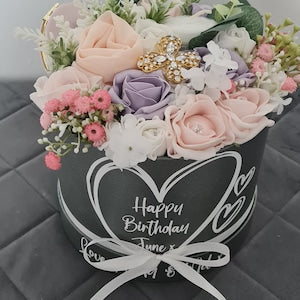 Floral gift bouquet in a decorative box with pink, purple, and white flowers
