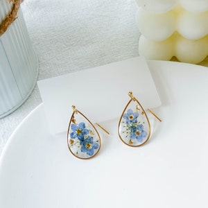 Gold forget-me-not resin drop earrings with teardrop glassy blue flower pendants