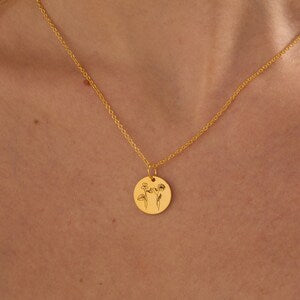 Gold-tone round pendant necklace with engraved flower design