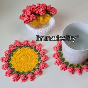 Crochet flower pot coaster set pattern: red crochet flower petals, yellow centers, yarn coasters.