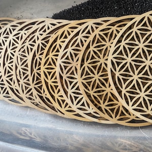 Wooden coaster with Flower of Life laser-cut geometric pattern in light tan