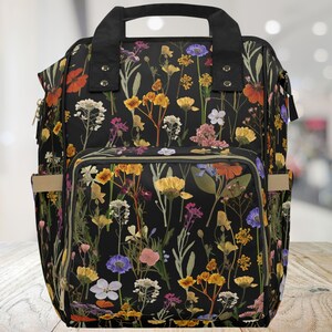 Black floral diaper bag with wide zipper top and front pocket, adjustable shoulder straps
