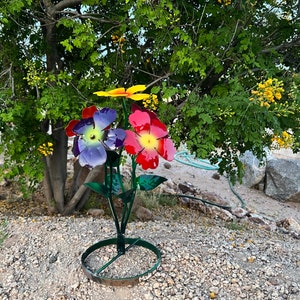 Vibrant metal flower bouquet yard art with purple, pink, and yellow blooms on standing base