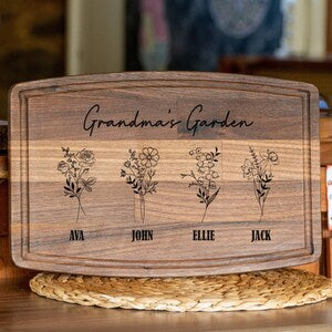 Wooden cutting board with arched top, engraved “Grandma’s Garden” and flower art with names Ava, John, Ellie, Jack