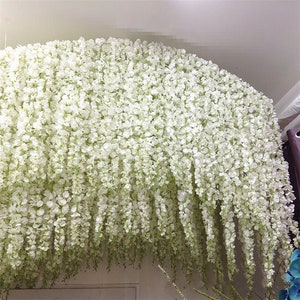 White artificial wisteria flower garland hanging in cascading strands for wedding decor