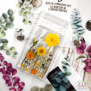 Pressed flower phone case skin with clear background and yellow, orange, and blue dried flowers