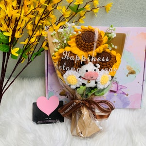 Wrapped bouquet of crochet flowers with sunflower and small cow ornaments