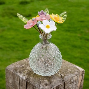 Glass flower bouquet with pastel blooms in textured clear glass vase
