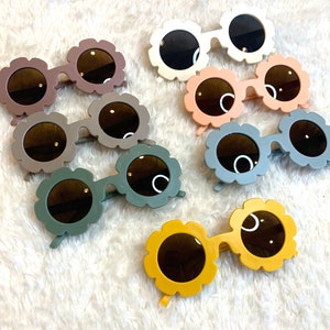 Flower-shaped kids sunglasses with dark lenses, various colors in a set