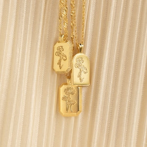 Gold-tone birth flower charm necklace with engraved rectangular and arch pendants