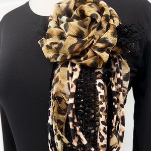 Leopard-print fabric flower brooch with ruffled layered petals and pin at center