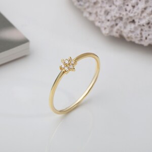 14K gold minimalist flower ring with small stone center, thin band