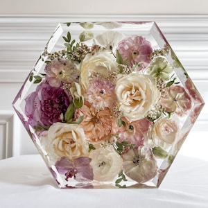 Resin floral preservation block with preserved pink, cream, and white flowers in a clear frame