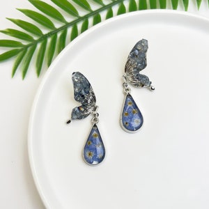 Teardrop pressed flower dangle earrings with blue butterfly charms